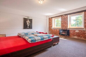Een slaapkamer met een bed, een open haard en een raam.