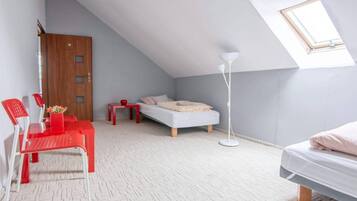 Una stanza compatta con soffitto spiovente, un letto, una scrivania e una sedia.