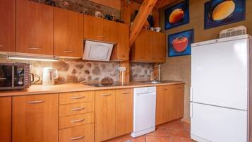 A kitchen with wooden cabinets, a microwave, a dishwasher, and a refrigerator.