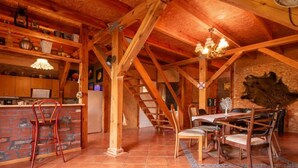 Een rustiek houten interieur met keuken, eethoek en een trap.
