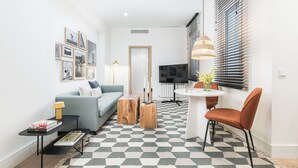 Een moderne woonkamer met een bank, salontafel en een eethoek met een tafel en stoelen.