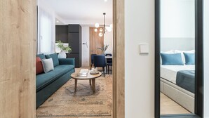 A modern living room with a sofa, coffee table, and a dining area with chairs. - Doctor Castelo xxviii (Madrid)