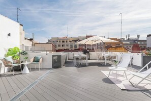 A rooftop terrace with outdoor seating, a table, and a large umbrella. - Doctor Castelo XLIV - One Bedroom Apartment, Sleeps 2 (Madrid)