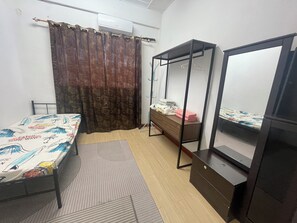 Une chambre à coucher avec un lit, une commode, une armoire et un miroir.