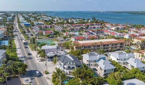 A coastal residential area with multiple buildings, a road, and a body of water. - New! Beautiful beach house with heated Pool & Spa! (Holmes Beach)