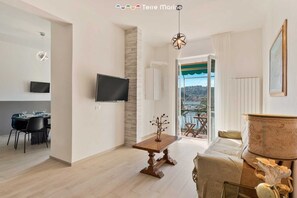 Un soggiorno moderno con zona pranzo, TV a parete e balcone con vista.