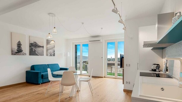 Un apartamento moderno con comedor, sofá y cocina.