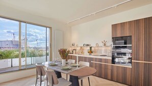 Een moderne keuken met een groot eiland, inbouwapparatuur en uitzicht op de stad.