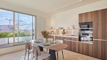 A modern kitchen with a large island, built-in appliances, and a view of the city.