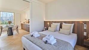 Een moderne hotelkamer met een groot bed, een zithoek en uitzicht op de stad.