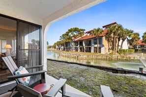 A balcony with a view of a water body and adjacent buildings. - Edgewater Villas 1BR | Pools, Beach Access, & Golf (Panama City Beach)