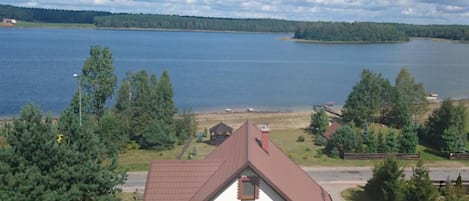 A house with a sloped roof, a satellite dish, and a view of a lake.