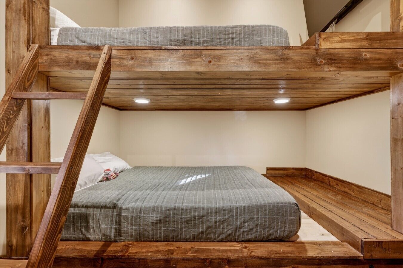 A bunk bed with a ladder, a mattress, and a pillow.