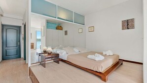Ein Schlafzimmer mit einem großen Bett, einem Schreibtisch und einem Kleiderschrank mit Glastür.