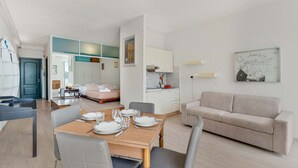 Ein modernes Wohnzimmer mit Essbereich, einer Couch und einer Küche.