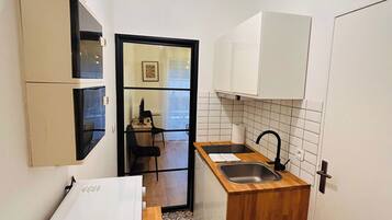 Een microgolfoven, een broodrooster, kookgerei, borden en bestek