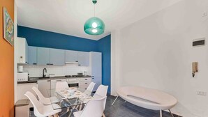 A modern kitchen with white cabinets, a dining table with white chairs, and a unique bathtub. - Blue Sign – Your corner of the sea in Le Grazie, PortovenereLocated in the picturesque village of Le Grazie, a hamlet of the municipality of Portovenere, Blue Sign is a holiday home with a refined and welcoming style, perfect for those looking for a re (Le Grazie)