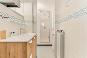 A modern bathroom with a wooden vanity, a shower, and a radiator. - In the picturesque seaside village of Fezzano, just minutes from La Spezia and Portovenere, lies Casa al Quarto, a spacious and bright apartment on the fourth floor of a typical Ligurian house (no elevator).The apartment can accommodate up to 5 people an (Fezzano)