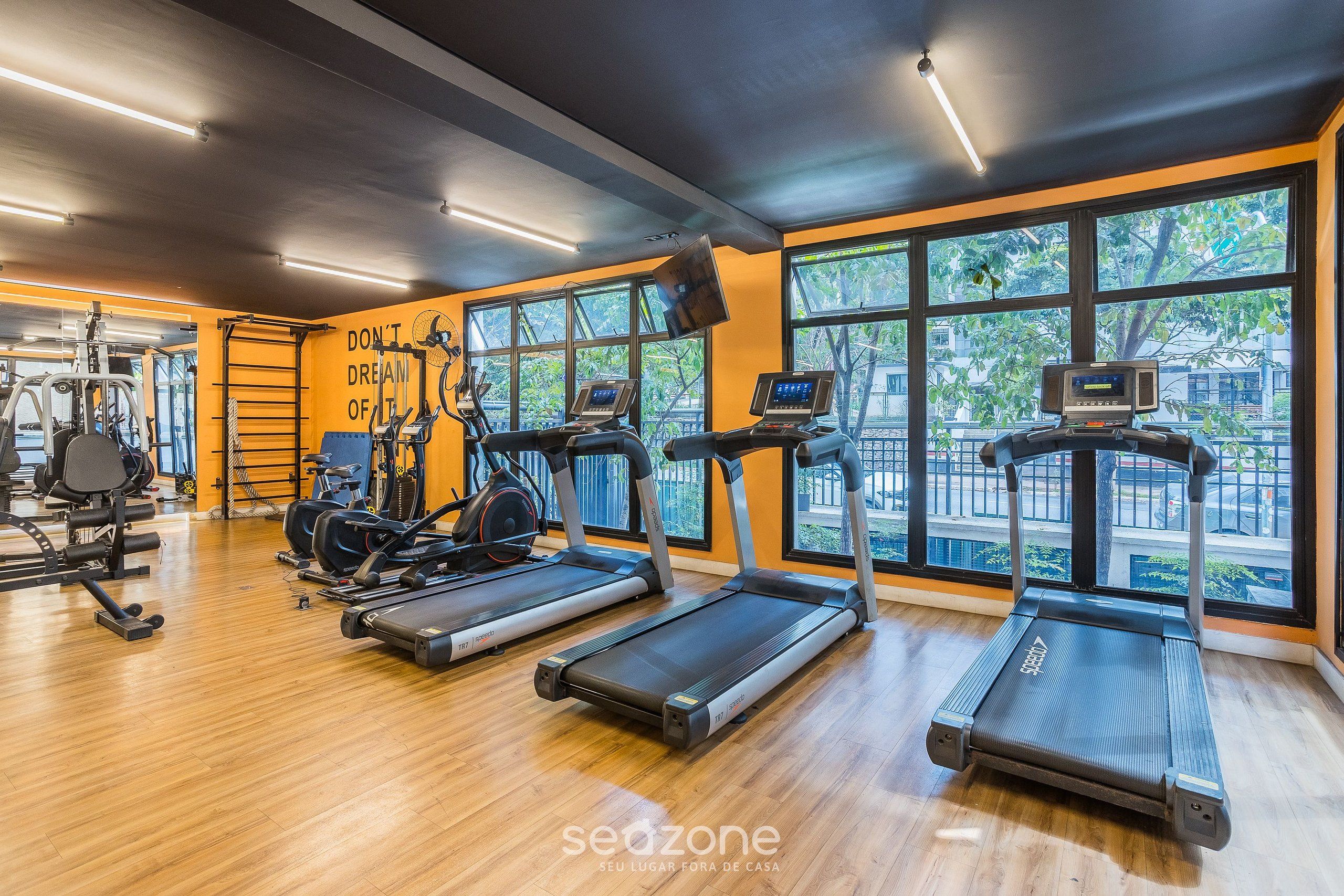 A gym with treadmills, weights, and a motivational wall.