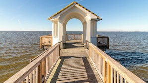 A wooden pier leading to a white gazebo with a tiled roof, overlooking a body of water. - Soundfront pet-friendly Corolla home w/ private pool & hot tub! (Corolla)