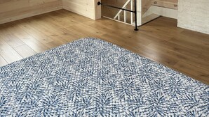 Una habitación con paredes de madera, una escalera y un ventanal grande.