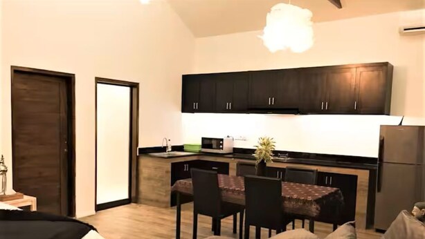 A compact living space with a kitchenette, a dining area, and a sofa. - Umalas Studio Near Canggu & Seminyak • Fast Wi-Fi + Kitchen (Badung Regency)