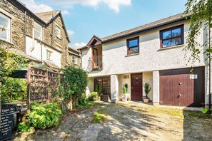 A courtyard with stone paving, a wooden fence, and potted plants. - The Retreat with Free Parking (Ambleside)