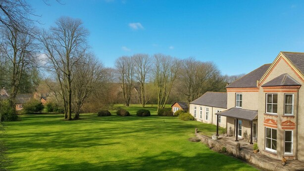 A large house with a well-maintained lawn and trees in the background. - Louisville Flat 3 in Newmarket (Newmarket)