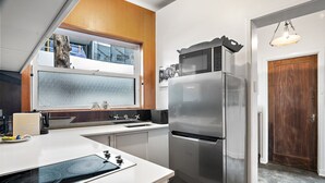 Una cocina moderna con horno empotrado, microondas y refrigerador.