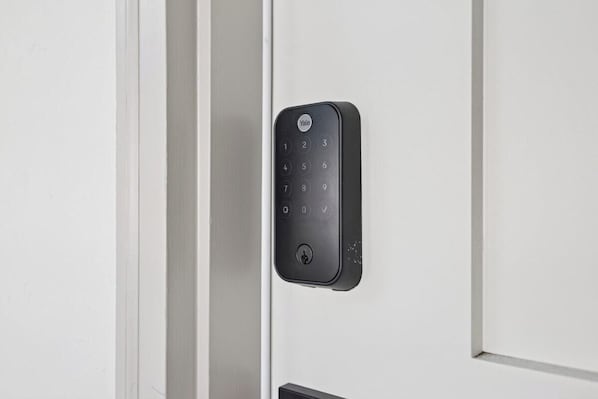 A Yale smart lock installed on a white door. - Casa Yano by The Beach (Santa Barbara)