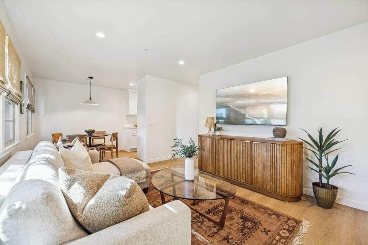 Un salon moderne avec un canapé, une table basse et un meuble en bois.