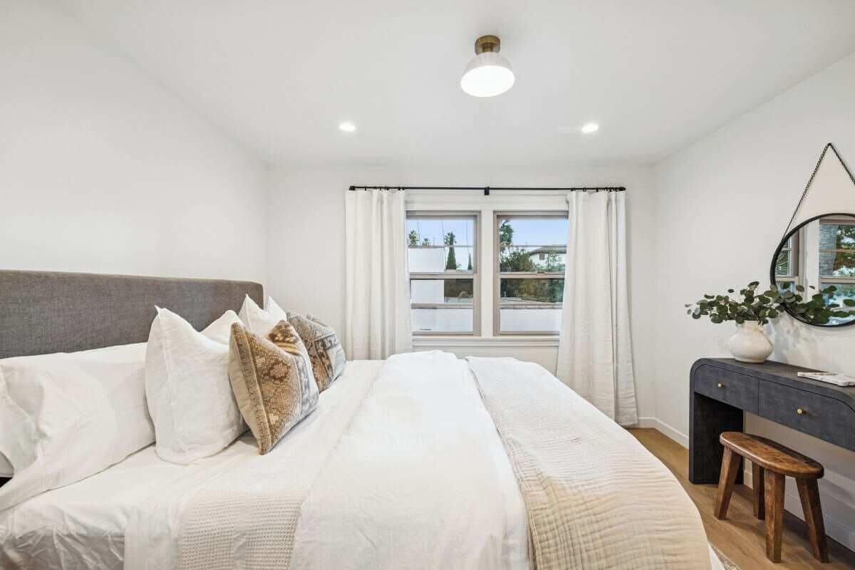 Ein Schlafzimmer mit einem Bett, einem Schreibtisch und einem Spiegel.