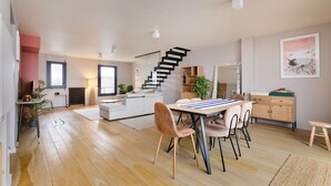 Ein zeitgemäßer Wohnraum mit Essbereich, Küche und Treppe.