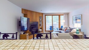 Un salon moderne avec une cheminée, un téléviseur et un espace détente.