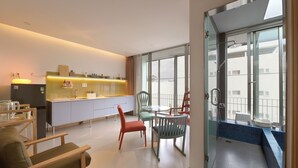 Una habitación de hotel moderna con cocina, comedor y balcón con vistas.