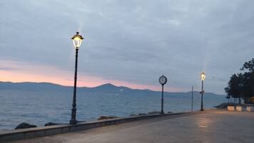 Una passeggiata lungomare con lampioni e un orologio.