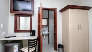 A small kitchenette with a refrigerator, a microwave, a coffee maker, and a sink. There is a wooden cabinet and a television mounted on the wall. - PLM Golden Lodge (Berea)