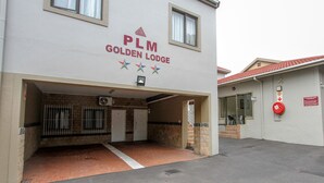 The exterior of PLM Golden Lodge with a brick entrance, a covered parking area, and a visible fire extinguisher. - PLM Golden Lodge (Berea)