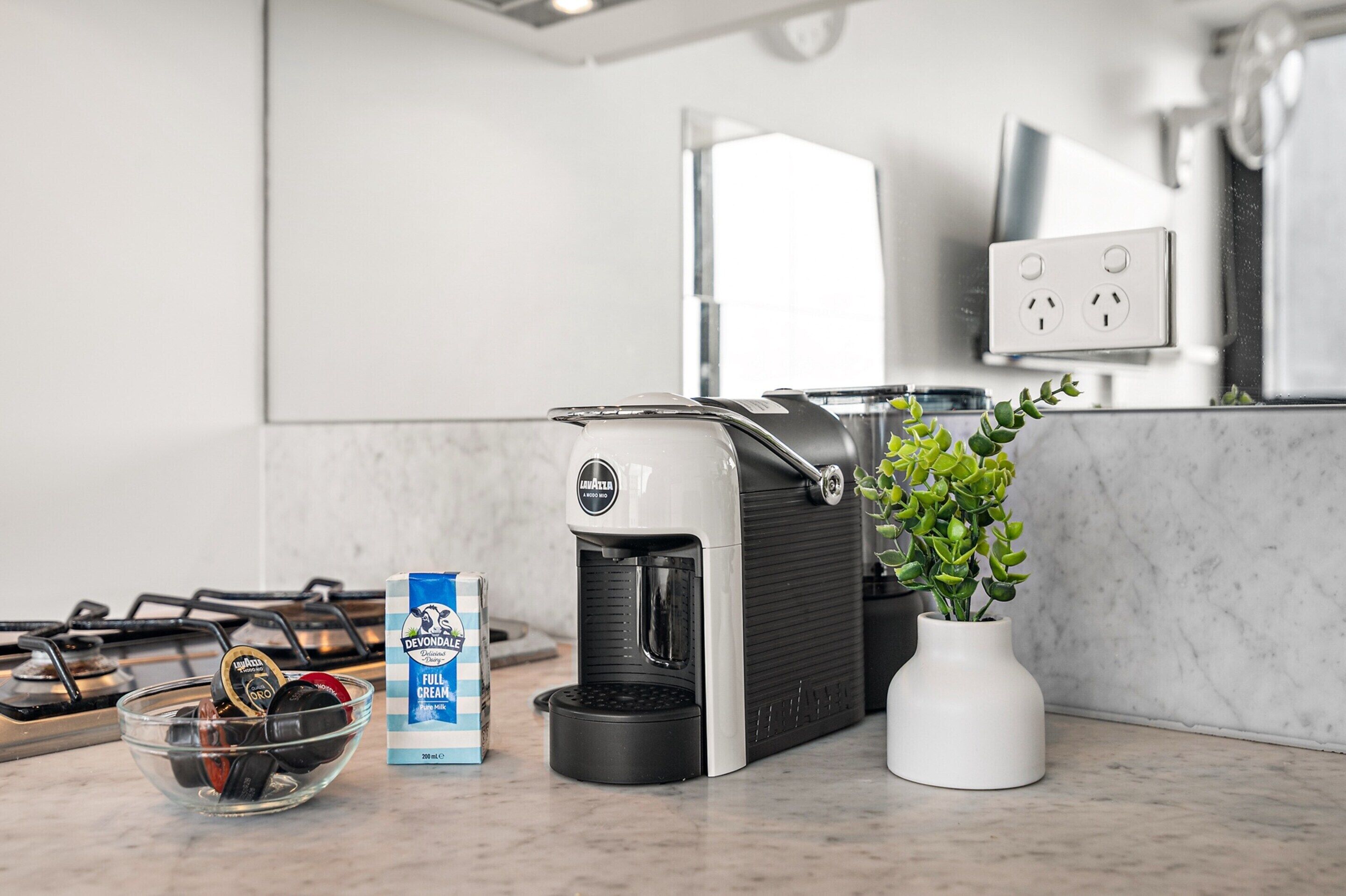 Eine Küche mit Kaffeemaschine, einer Schale mit Kaffeekapseln und einer Packung Kaffeewahner.