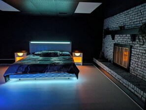 Un dormitorio moderno con una cama grande, dos lámparas de noche y una pared de ladrillo.
