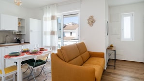 Un salon moderne comprenant un canapé, une table à manger et un coin cuisine.