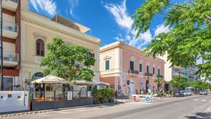 Una calle con edificios, un café con terraza y una señal de prohibido el paso.