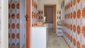 A hallway with patterned tiles, a white counter with a basket of bread, and a white cabinet. - Casina Gigina by BarbarHouse (Torre Specchia Ruggeri)