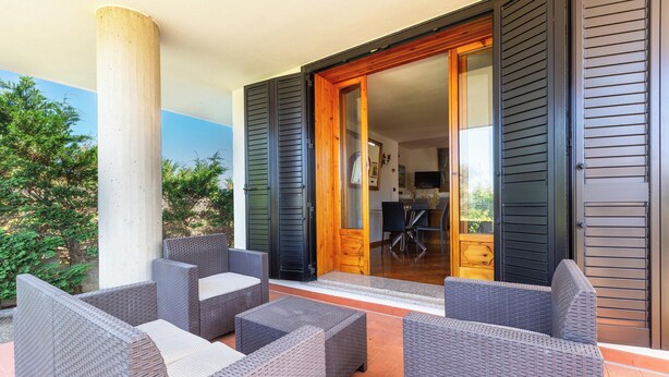 An outdoor patio with wicker furniture and a sliding glass door leading to a room. - Villa di Carmen by BarbarHouse (Castrignano del Capo)