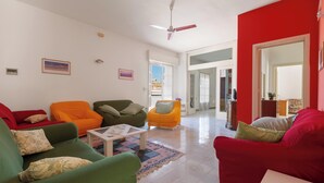A living room with a ceiling fan, a coffee table, and multiple sofas in various colors. - Nando`s Bellavista House By BarbarHouse (Porto Cesareo)