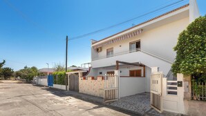 A two-story house with a white exterior, a gated entrance, and a small balcony. - Nando`s Bellavista House By BarbarHouse (Porto Cesareo)