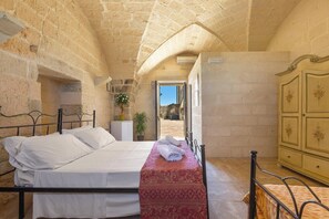 Une chambre à coucher avec un lit, une table de chevet, une armoire et une vue sur l’extérieur.