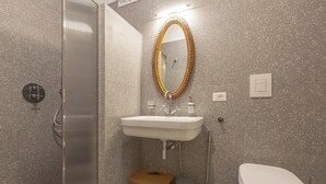 Une salle de bain équipée d’une douche, d’un lavabo, de toilettes et d’un miroir agrémenté d’un cadre décoratif.