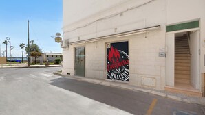 Un bâtiment sur lequel on peut lire l’inscription « La Taverneta Braceria », avec un escalier menant à l’entrée.