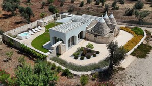 A modern villa with a swimming pool, a covered patio, and a landscaped garden. - Trullo Pumo by Perle di Puglia (San Michele Salentino)